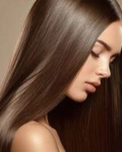 Woman with long, straight, glossy brown hair after keratin smoothing
