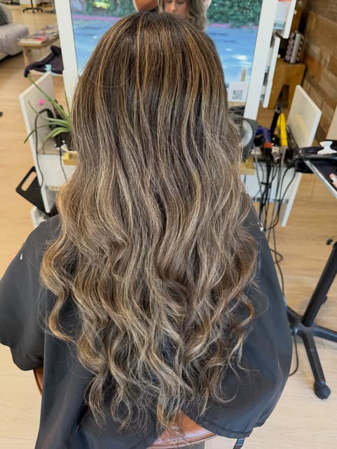 Long, wavy brown hair with blonde highlights by Gabriella Sophia at Salon Bravissimo