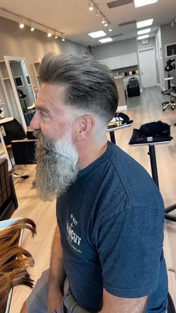 Men’s haircut with a tapered fade and a trimmed gray beard