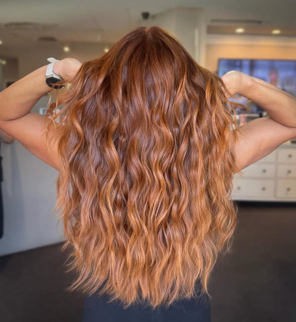 Long, wavy copper hair with golden highlights, seen from behind, by Sandra Bandimere at Salon Bravissimo